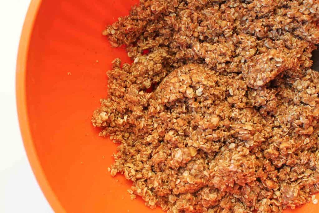 oats and other ingredients in an orange mixing bowl