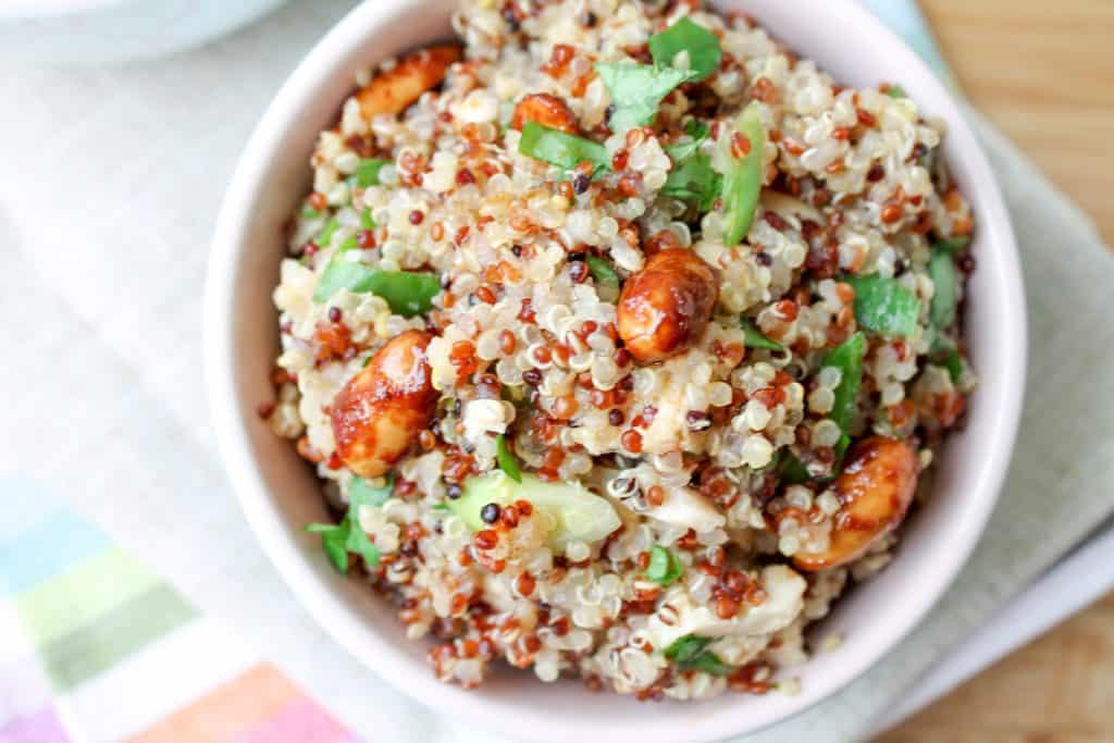 Lemon Chicken Quinoa Salad in a bowl with fresh lemons in the background