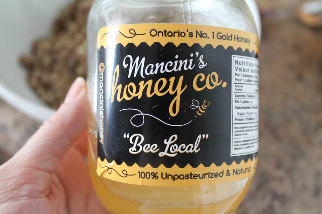 a hand holding a jar of local honey