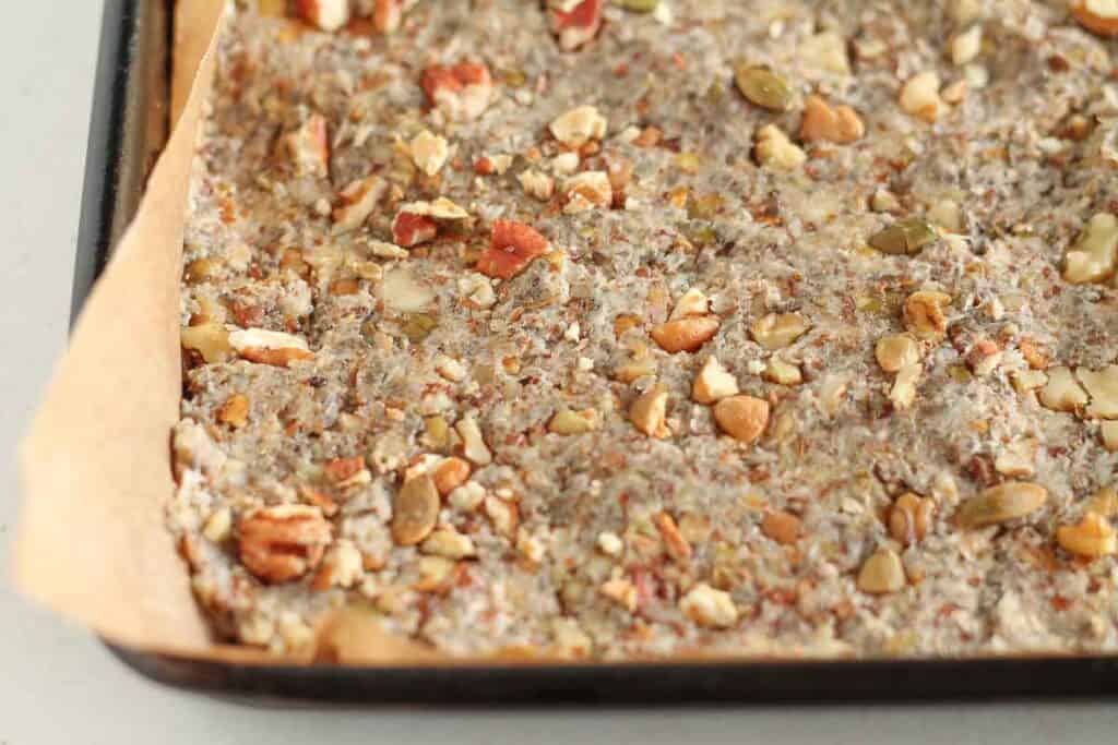 nuts, seeds and banana mixture pressed into a pan ready for the oven