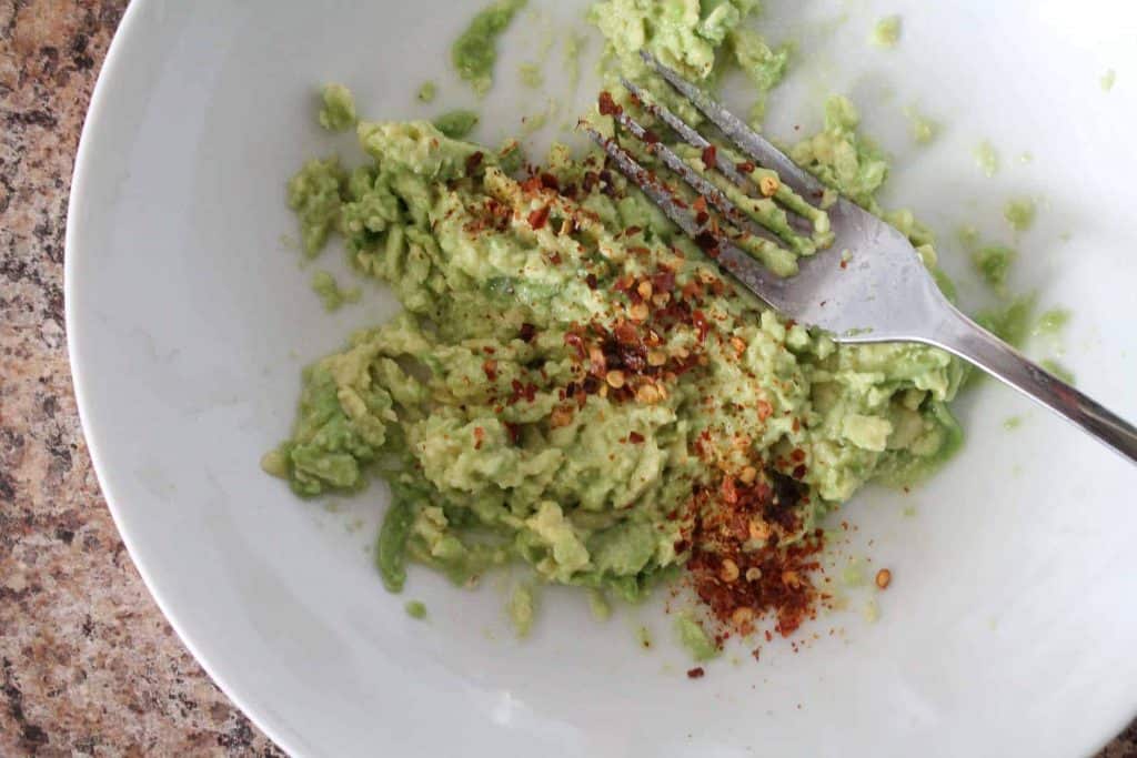 avocado being mashed with a fork