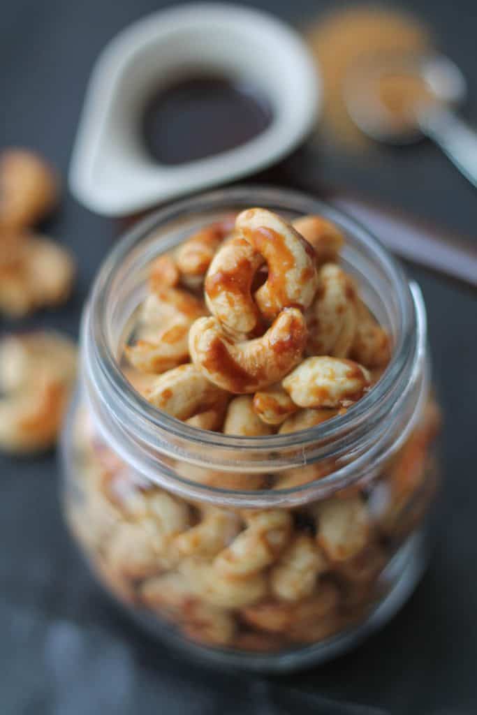 vegan and gluten free nuts in a mason jar with maple syrup in the background