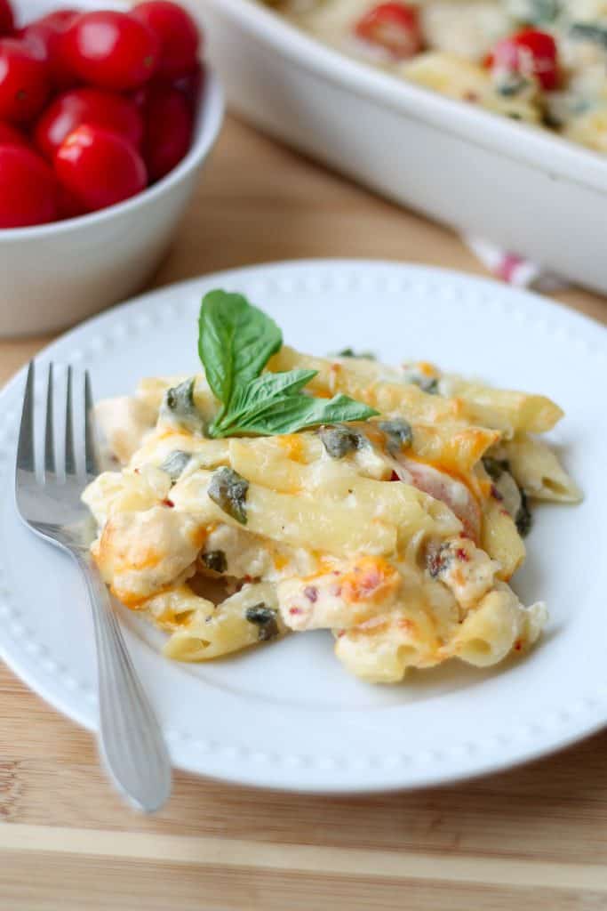 Creamy Garden Fresh Pasta Bake on a plate with fresh tomatoes in the background