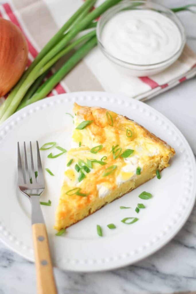 Sour Cream & Onion Frittata on a white plate with slices of green onion as a garnish