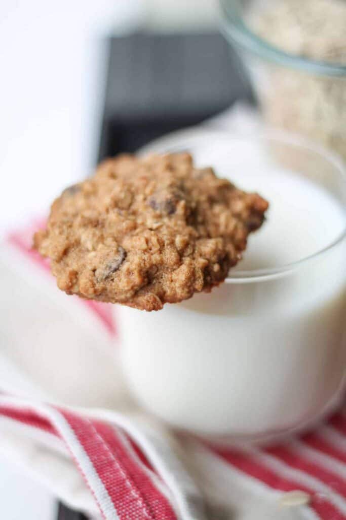 Oatmeal Chocolate Chip Cookie balancing on a glass of milk