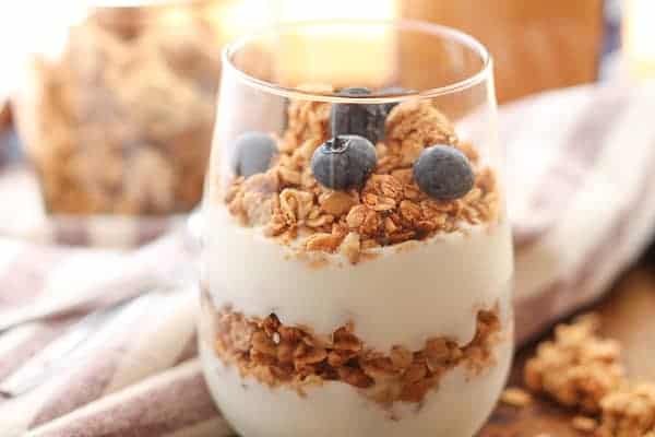 Gluten Free Granola layered with yogurt in a glass an topped with fresh blueberries