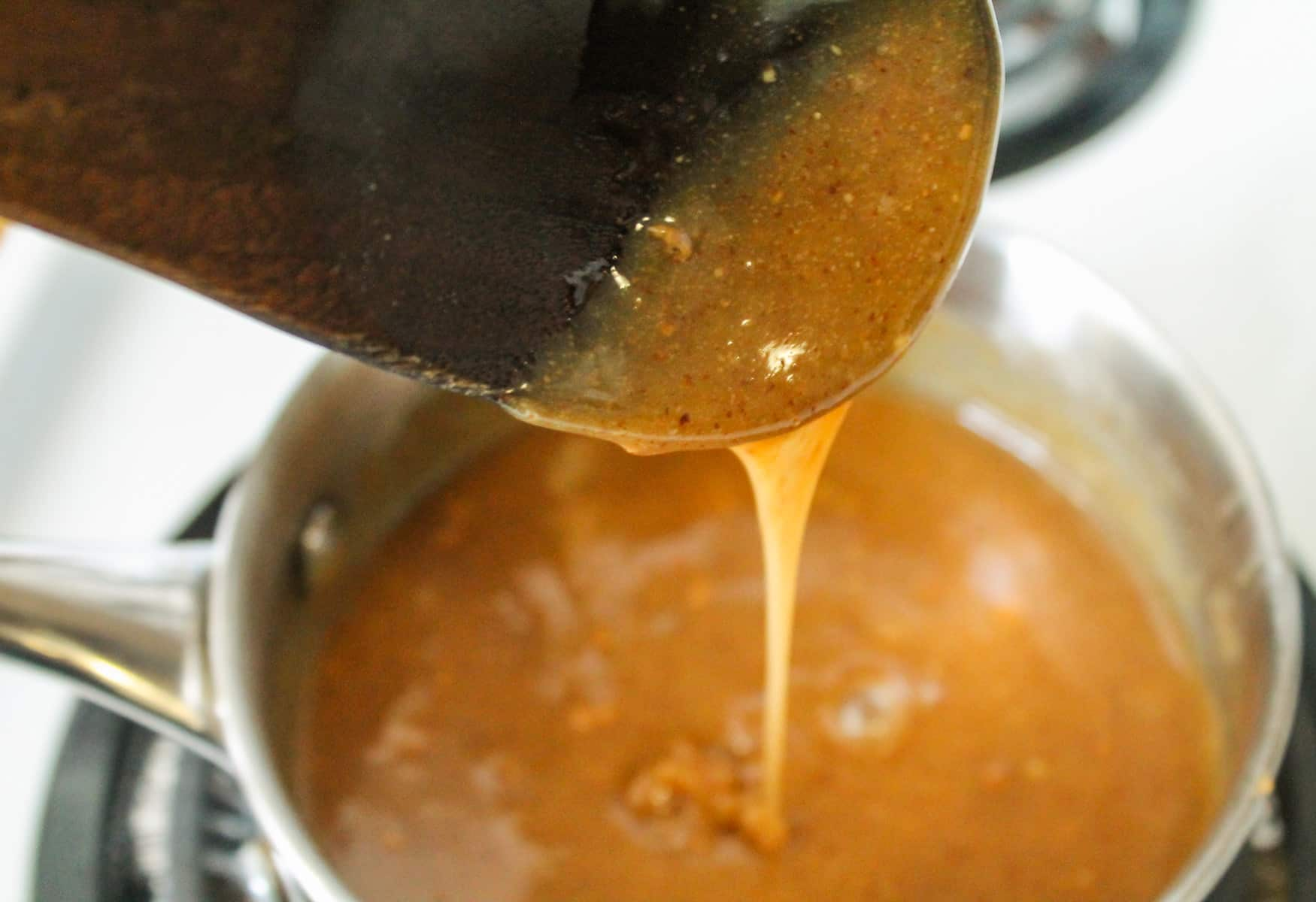 brown rice syrup and almonds butter being mixed together in a small saucepan.