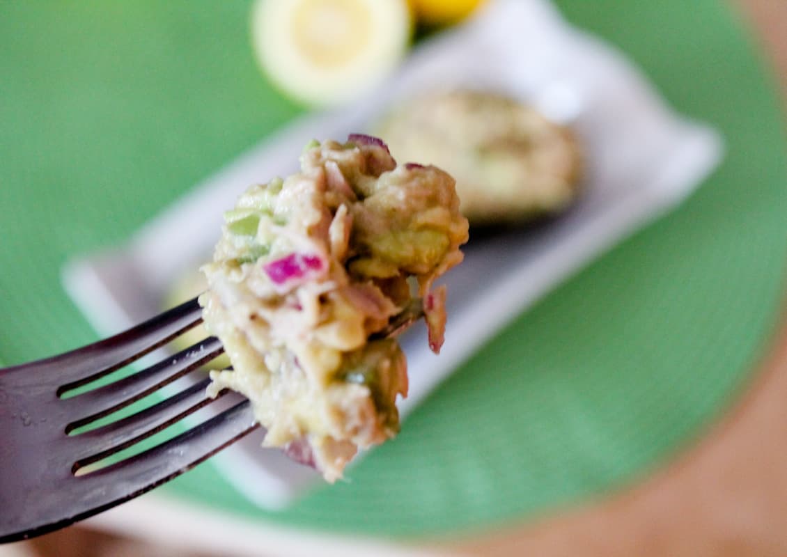 A fork full of avocado tuna salad.
