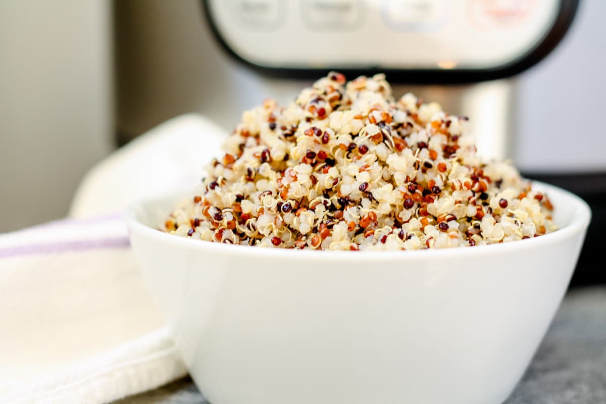 A bowl of quinoa in front of an Instant Pot.