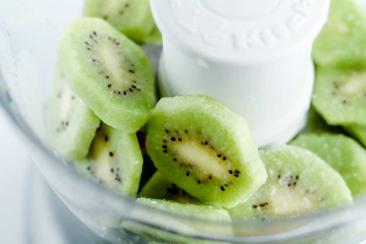 Slices of frozen kiwi in a food processor.
