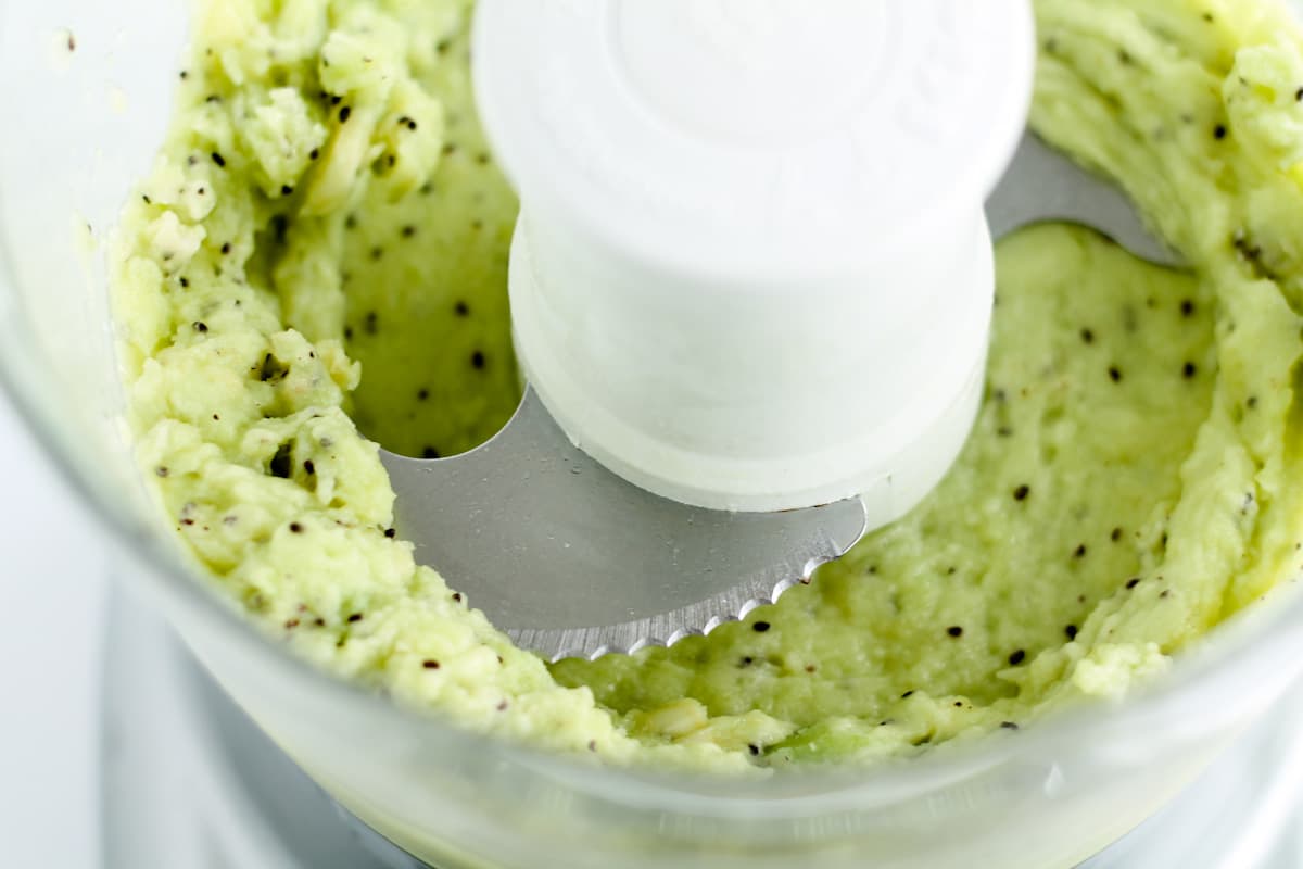 Frozen kiwi being blended.