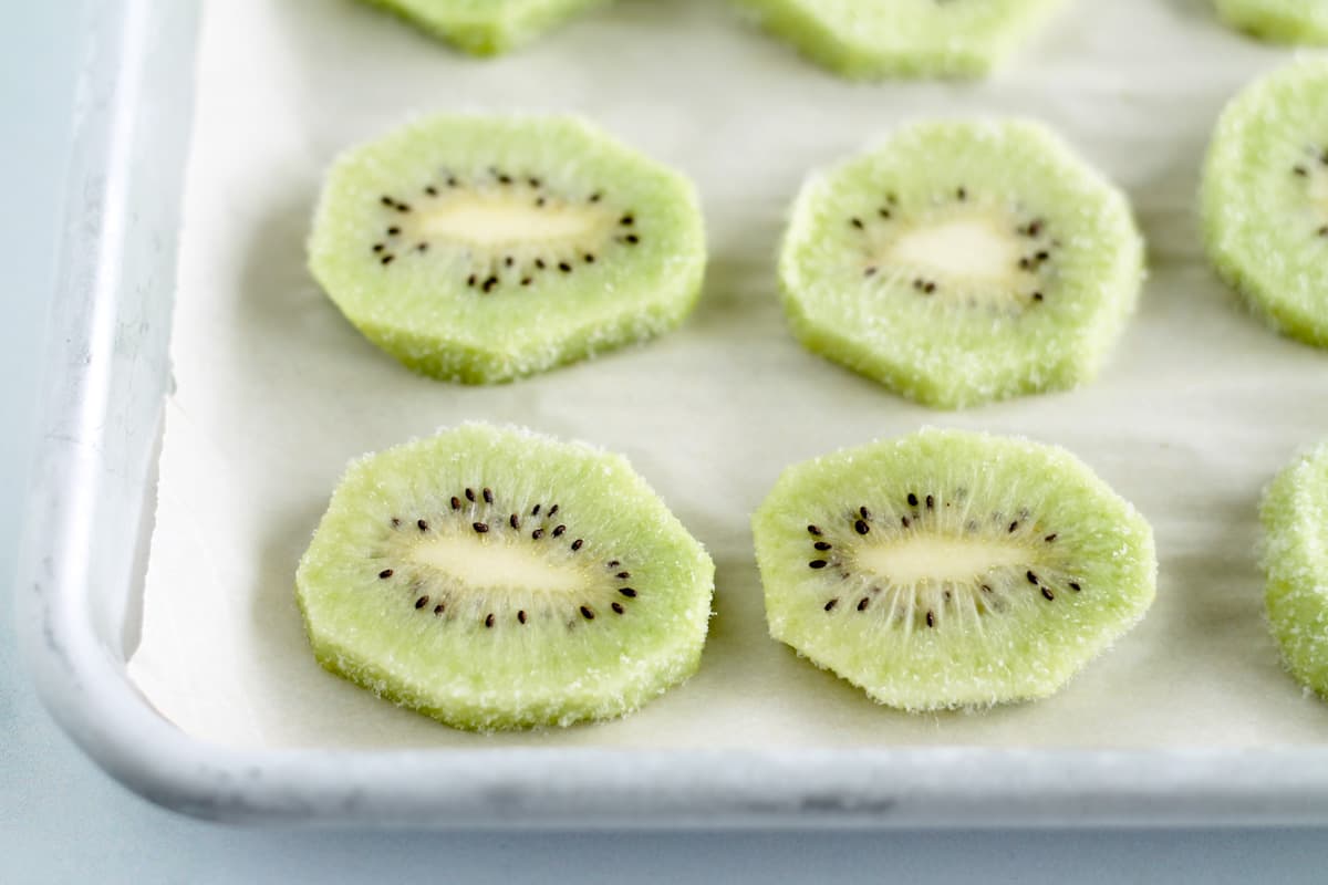 Frozen slices of kiwi on a tray.