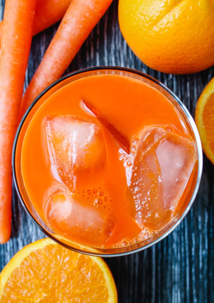 a glass with carrot orange over ice.