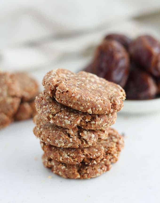 a stack of healthy cookies with dates in the background