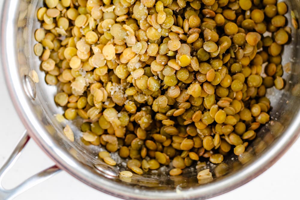 a pot of cooked lentils sprinkled with salt.