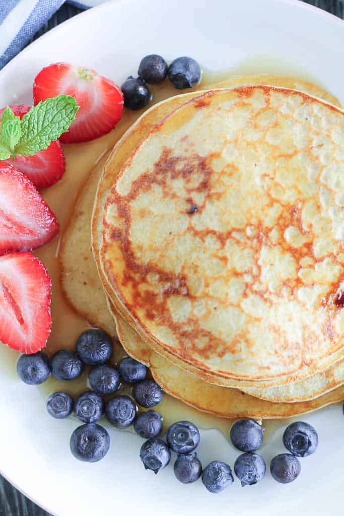 healthy blueberry pancakes on a plate with fresh berries
