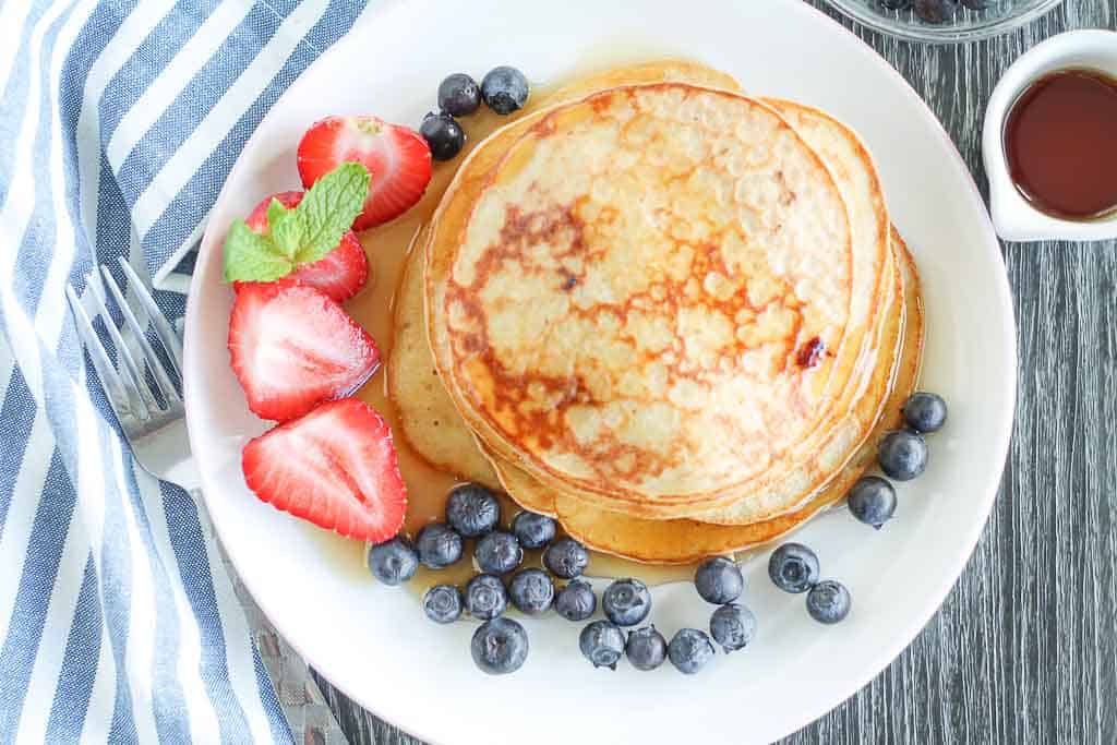 healthy blueberry pancakes on a plate with fresh berries