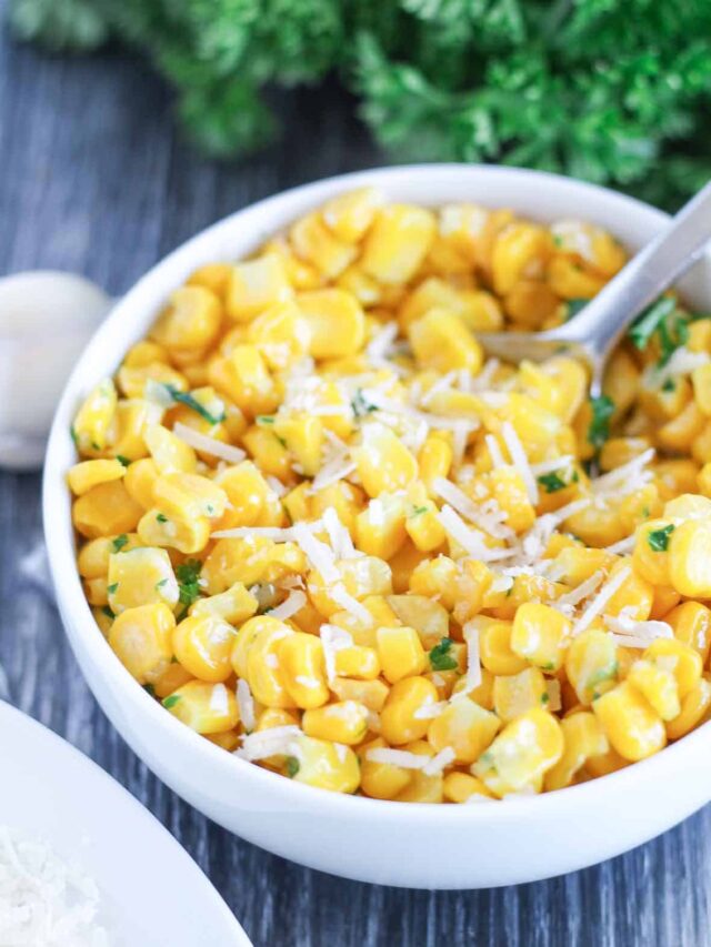 a bowl of garlic butter fried cor with fresh parsel and parmesan sprinkled on top