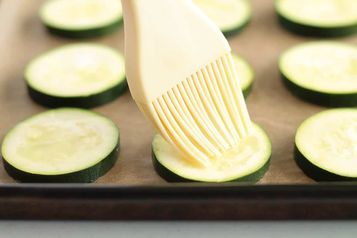 zucchini being brushed with olive oil