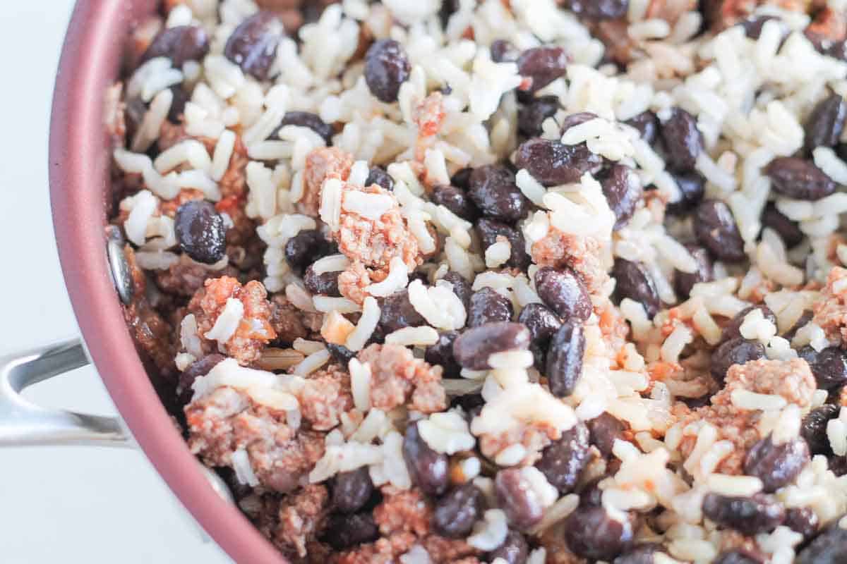 ground beef in a skillet with black beans and brown rice