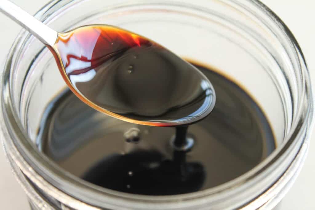 a spoon in a jar of homemade reduction