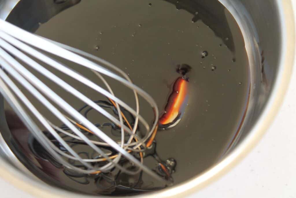 a whisk stirring balsamic vinegar in a saucepan