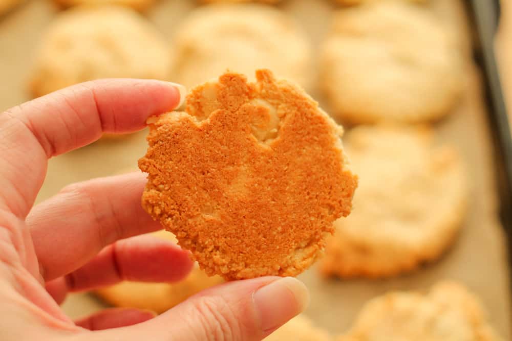 a hand holding a cookie showing a golden bottom.