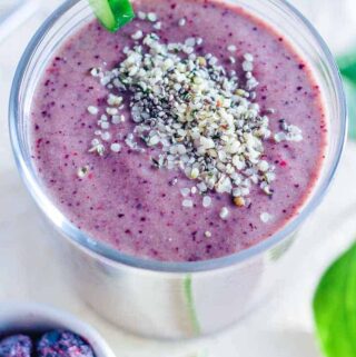 a glass filled with a blueberry spinach smoothie