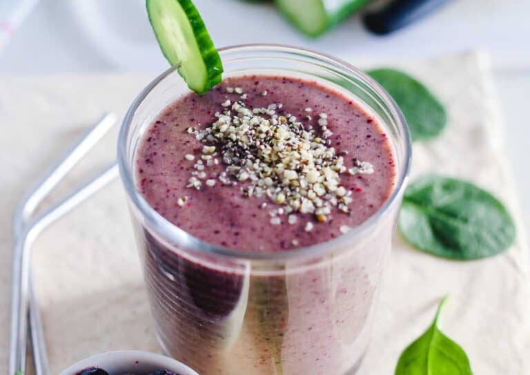 a glass filled with a blueberry spinach smoothie