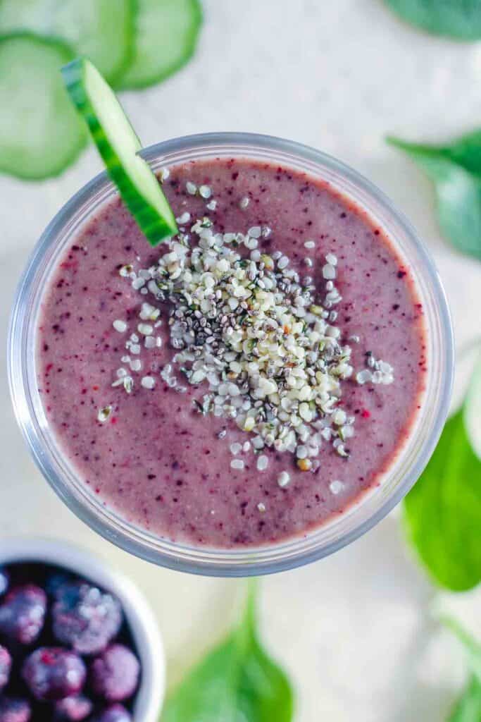 a glass filled with a blueberry spinach smoothie