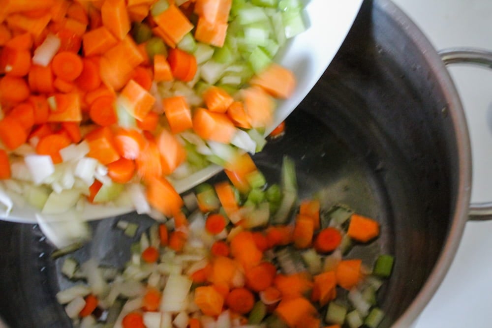 chopped veggies going into a pot.