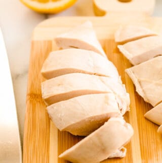 poached chicken breasts sliced on a board