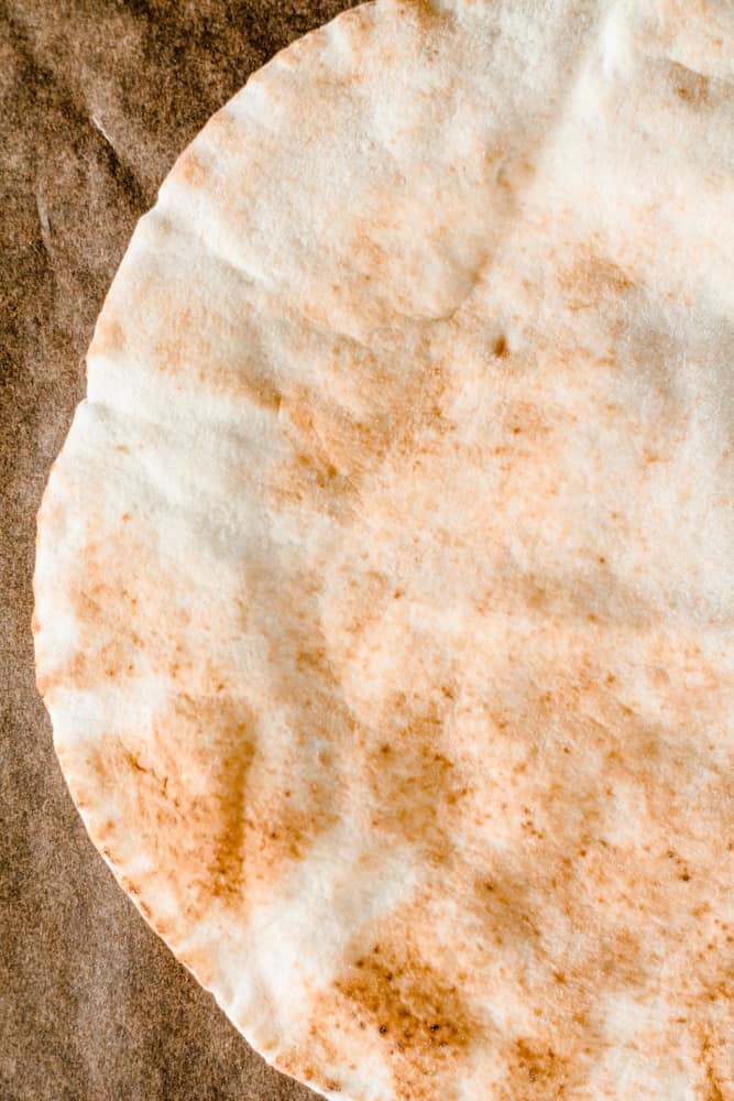  whole what pita bread on a counter.