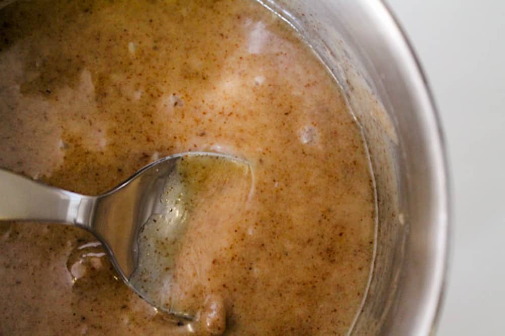 caramel apple dip being stirred in a saucepan.