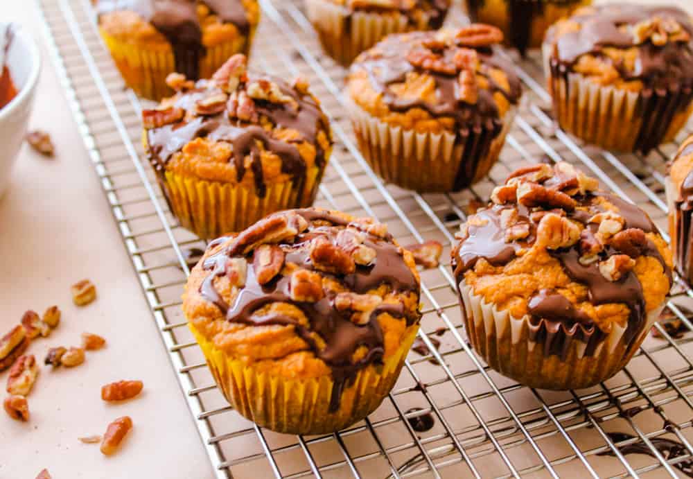 chopped pecans being added on top of cupcakes.