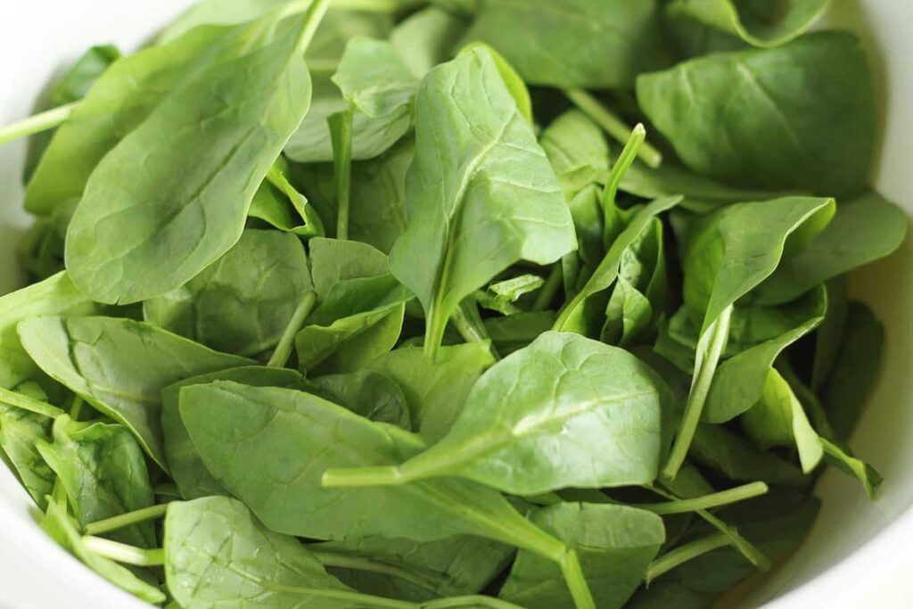 a bowl of baby spinach leaves.