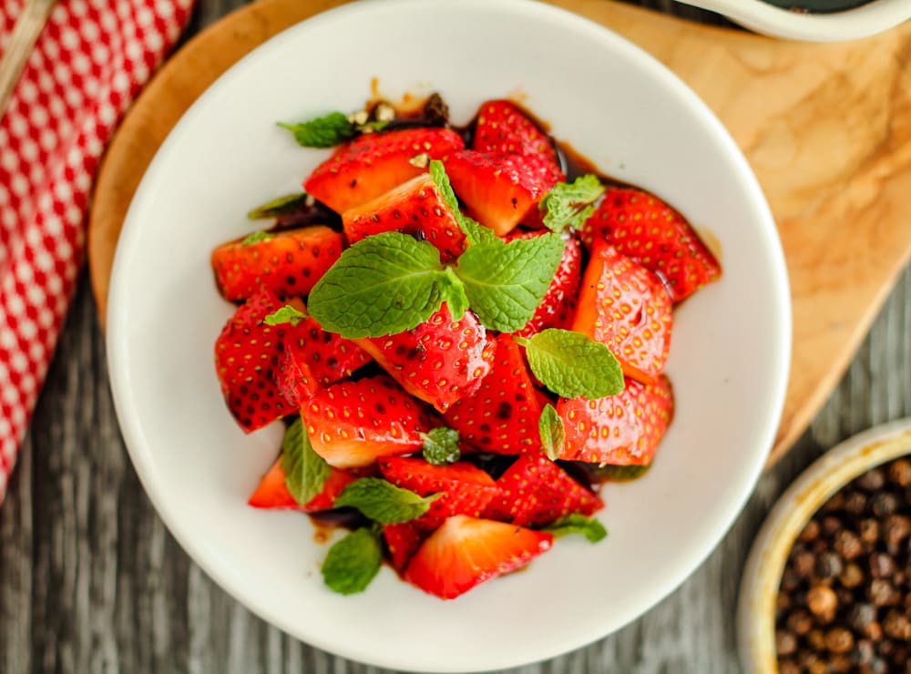 a dish of balsamic strawberries with mint.