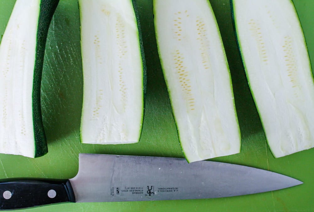 a zucchini sliced in half on a cutting board.