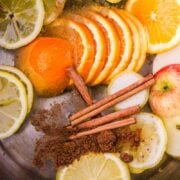 a simmer pot for fall with sliced fruit and spices in a large pot of water.