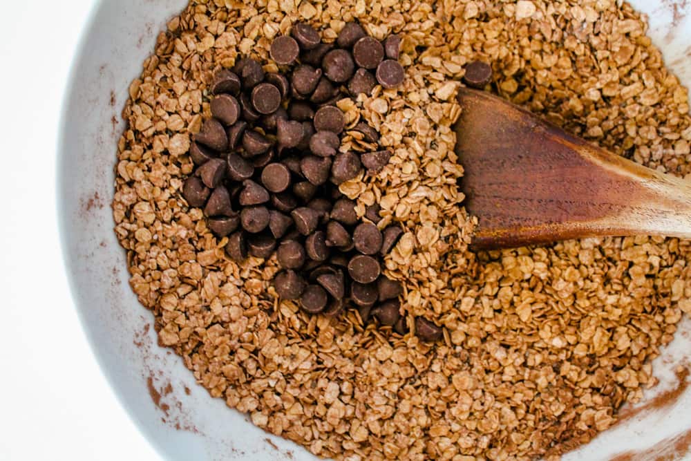 oats and chocolate chips being stirred in a bowl.