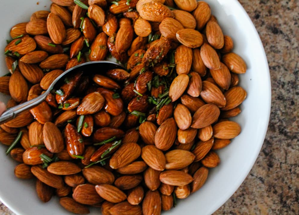 almonds being stirred with oil and spices.