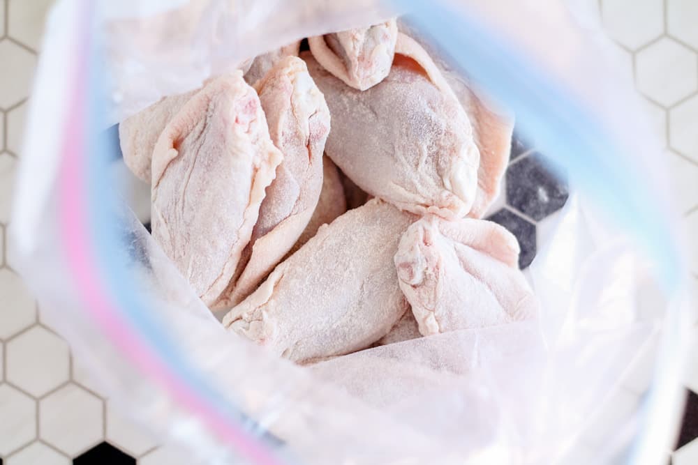 raw chicken wings in a ziploc bag coated with flour.