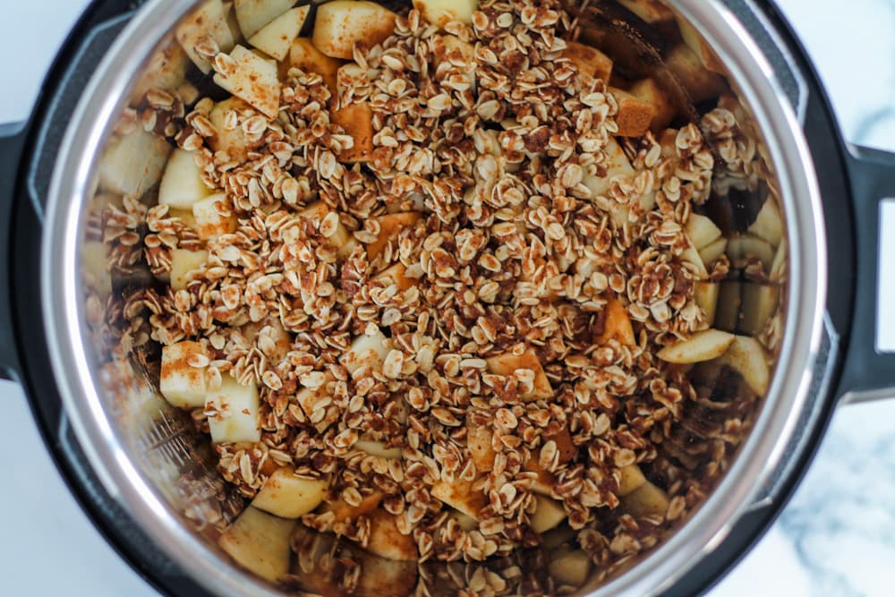 oat crumble topping over chopped apples in an instant pot.