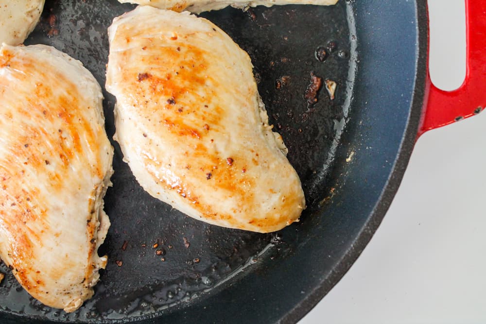 breasts cooking in a pan.
