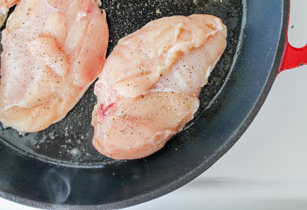 chicken breasts in a cast iron pan.