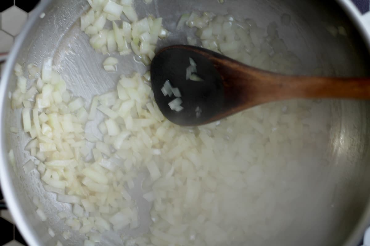 onions being sauteed in a soup pot.