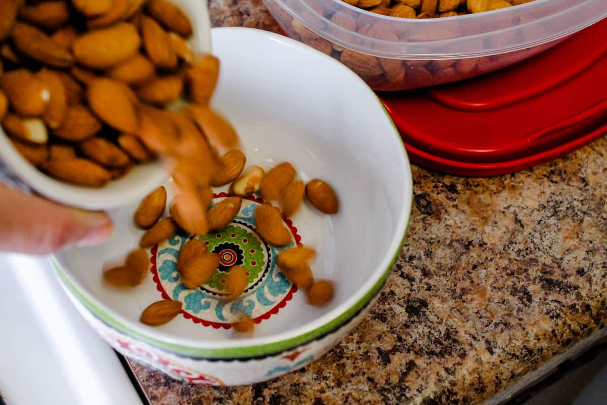 almonds being poured into a bowl.