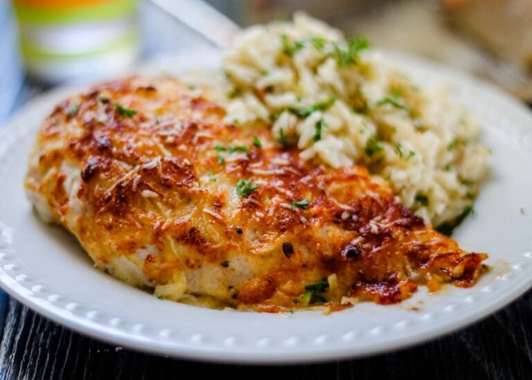 Parmesan crusted chicken breast on a plate.