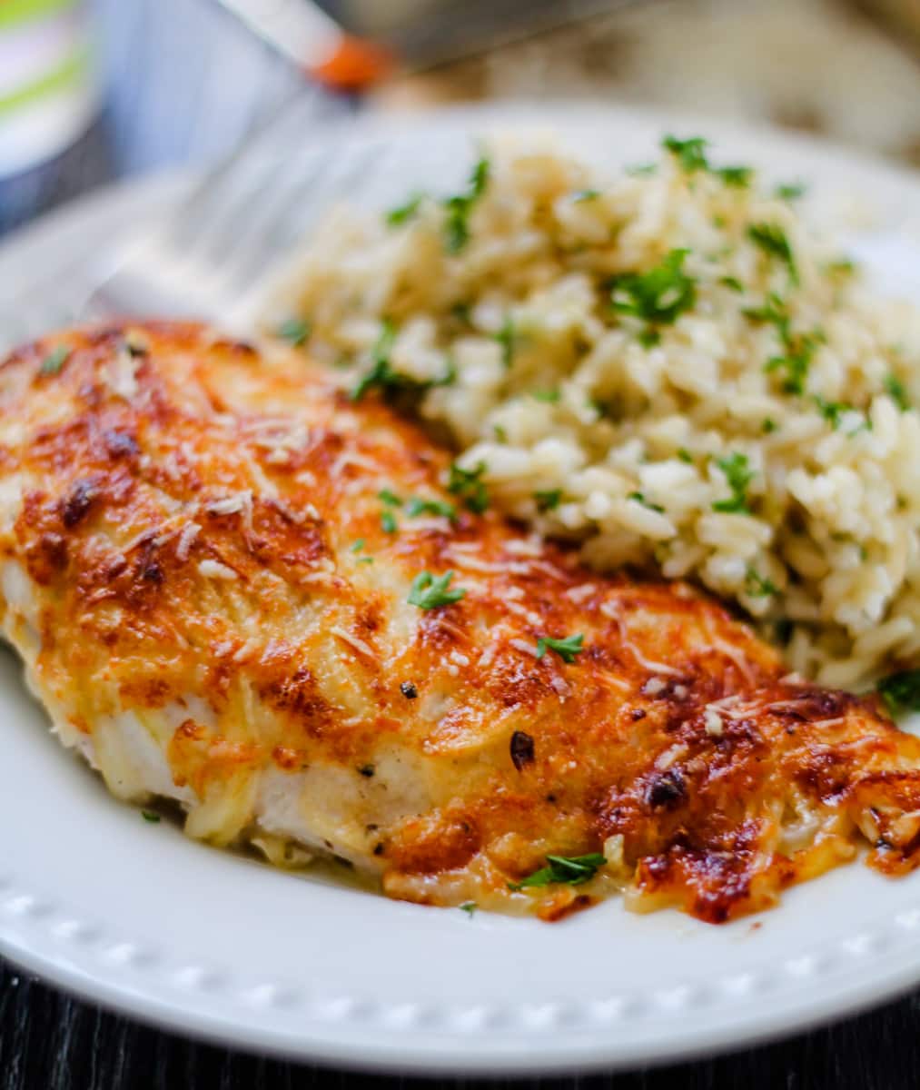 parmesan crusted chicken breast on a plate.