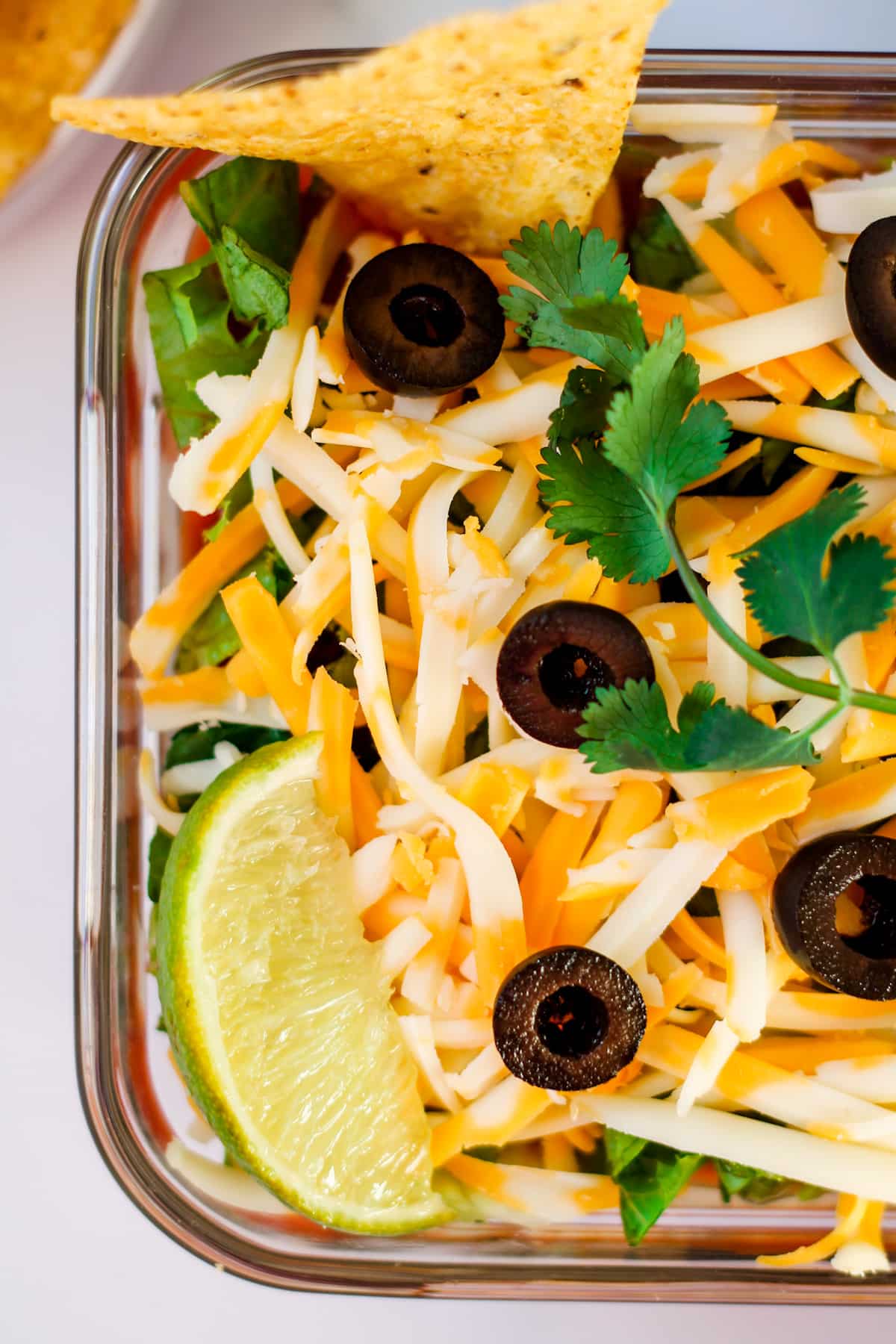 healthy 7 layer dip in a glass dish.